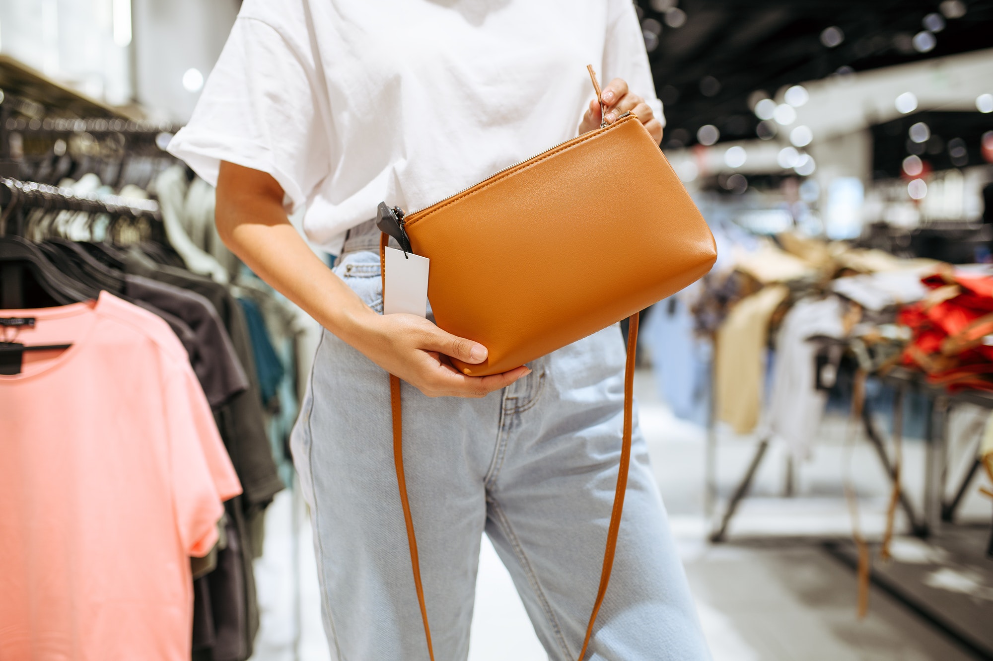 Woman holds handbag in clothing store